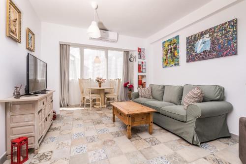 a living room with a couch and a table at Happy house Arenal in Jávea