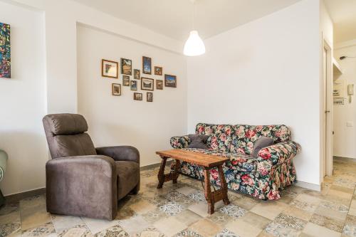uma sala de estar com um sofá e uma cadeira em Happy house Arenal em Xàbia
