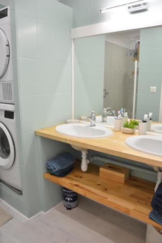 une salle de bain avec deux lavabos et une machine à laver dans l'établissement Grand appartement pour 8 - La Baule-Escoublac, à La Baule