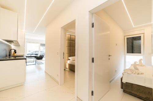 eine Küche und ein Wohnzimmer mit weißen Wänden in der Unterkunft Apartments Ante in Novalja