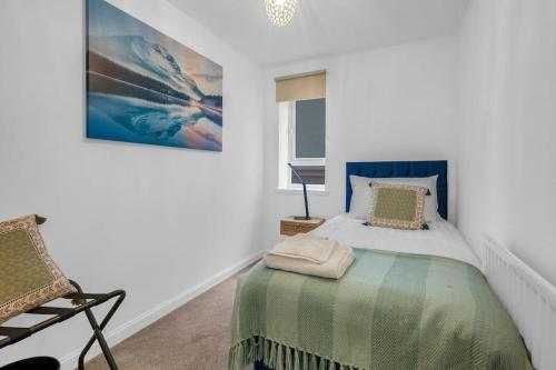 a bedroom with a bed and a painting on the wall at 2 Bedroom Apartment on South Beach Road, Ayr in Ayr