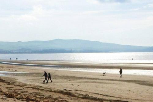 a group of people walking on the beach at 2 Bedroom Apartment on South Beach Road, Ayr in Ayr