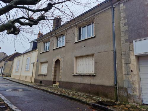 an old brick house with white windows on a street at Halte Douillette au cœur de la Ville in Châteaudun