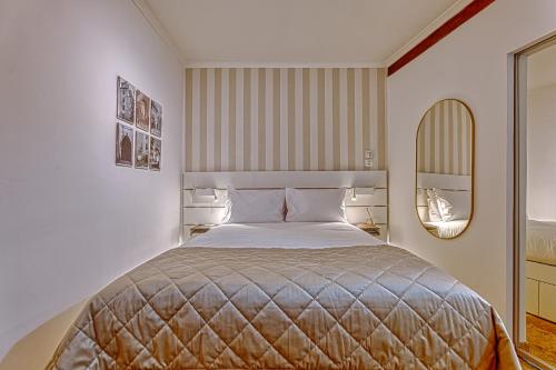 ein Schlafzimmer mit einem großen Bett und einem Spiegel in der Unterkunft Porta da Muralha de Lisboa 1375 in Lissabon