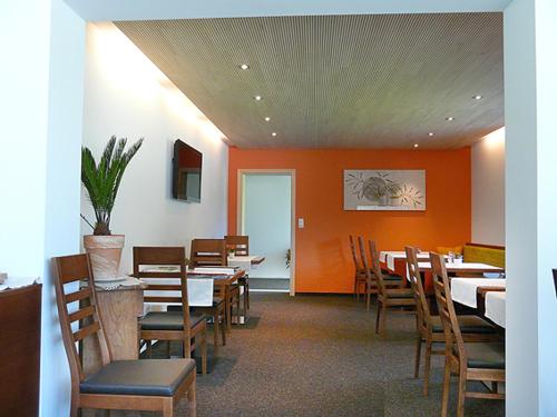 d'une salle à manger avec des tables, des chaises et des murs orange. dans l'établissement Hotel Garni Madrisa, à Brand