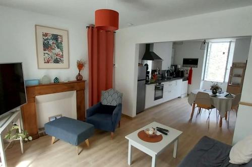 un salon avec une table et une cuisine dans l'établissement Gite du Porche 79700 Mauléon 20min Puy du FOU, à Mauléon