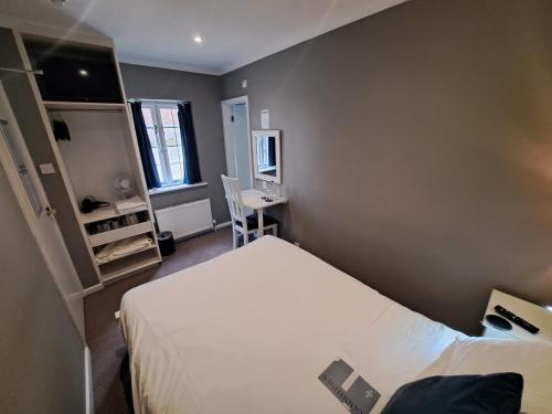 Mały pokój z łóżkiem i biurkiem w obiekcie The Thatch Inn w mieście Gloucester
