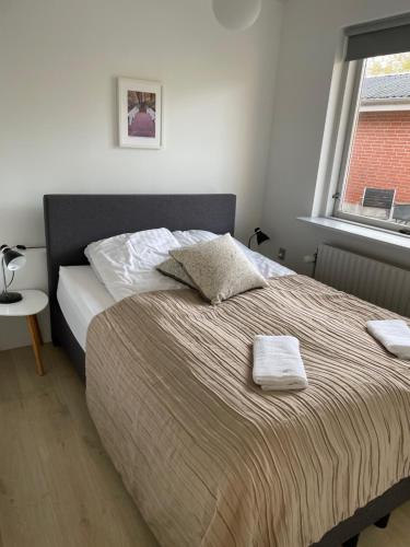 ein Bett mit zwei Handtüchern darauf in einem Schlafzimmer in der Unterkunft Søhusets anneks1 in Viborg
