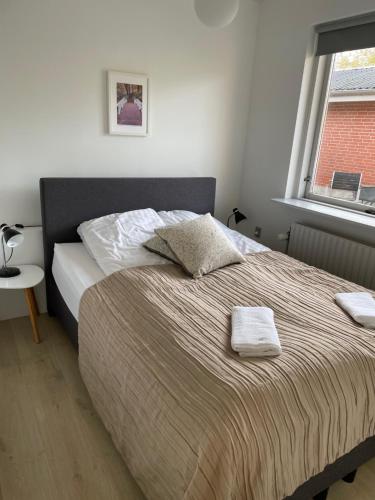 a bed with two towels on it in a bedroom at Søhusets anneks1 in Viborg