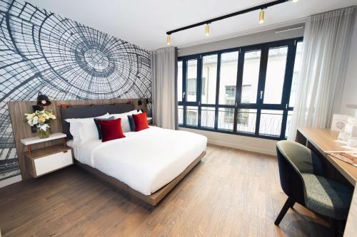 Mode Paris Aparthotel في باريس: غرفة نوم بسرير ابيض ومخدات حمراء