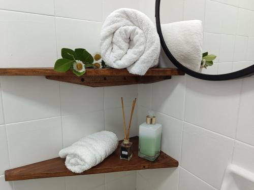 baño con estantes de madera, toallas y espejo en Hospedagem do Mathe en União da Vitória