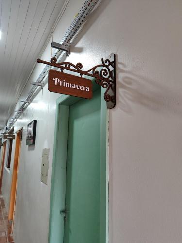 un panneau suspendu au-dessus d'une porte dans un couloir dans l'établissement Hospedagem do Mathe, à União da Vitória
