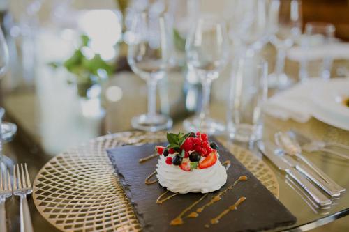 a dessert on a plate on a table with glasses at Pałac Pakoszów Schlosshotel Wernersdorf in Jelenia Góra