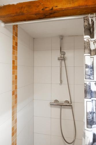 a shower in a bathroom with white tiles at Kings Inn City Hotel Alkmaar in Alkmaar