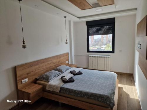 um quarto com uma cama e uma janela em Serbian home - 44 em Bežanija