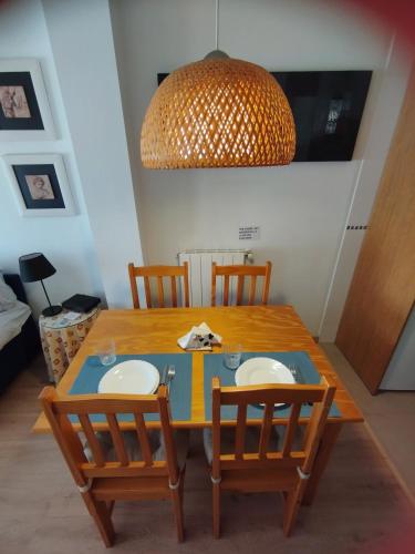 a dining room table with four chairs and a lamp at Acogedor Apartamento En Huesca in Huesca