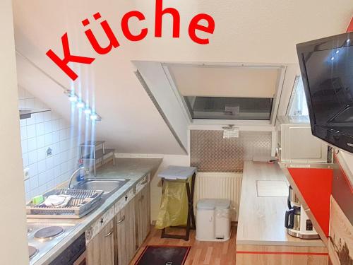 a small kitchen with a sink and a tv at Hotel Garni Rodenbach in Rodenbach