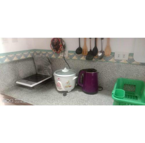 a kitchen counter with a tea pot and a toaster at Homey Studio Condo by Malou in Calamba