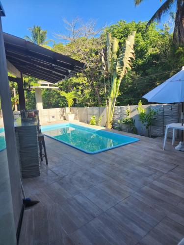 a swimming pool in a patio with a table and an umbrella at Casa Parque de Olivenca in Pontal
