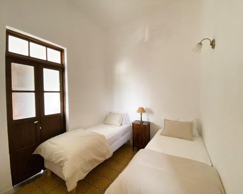 Duas camas num quarto com paredes brancas e uma janela em Casa Álvaro em Fasnia