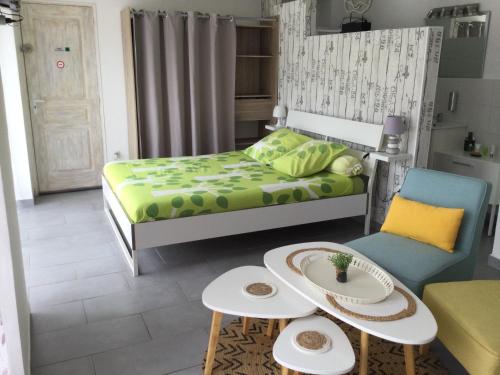 a small bedroom with a bed and a table and chairs at La Salamandre de Camargue in Salin-de-Giraud