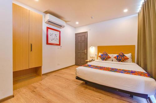 um quarto com uma cama grande num quarto em FabHotel NY Townhouse em Ahmedabad