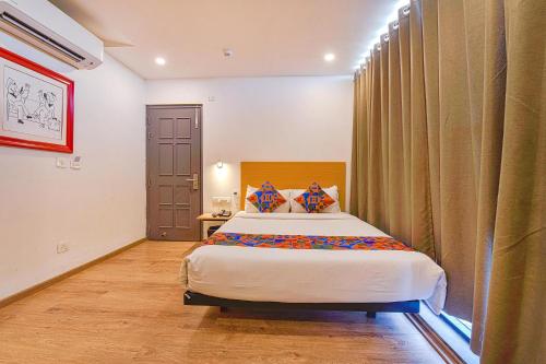 Schlafzimmer mit einem Bett und einem Fenster in der Unterkunft FabHotel NY Townhouse in Ahmedabad