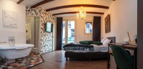 uma casa de banho com uma banheira e uma cama e uma banheira em Kings Inn City Hotel Alkmaar em Alkmaar