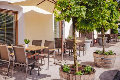 a patio with a table and chairs and trees at Hotel Kaiserhof in Anif