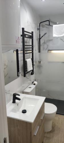 a white bathroom with a sink and a toilet at Apartamento Centro B in San Sebastián de los Reyes