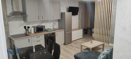 a small kitchen with white cabinets and a table at Apartamento Centro B in San Sebastián de los Reyes