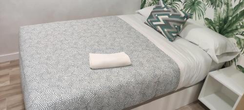 Una cama blanca con una almohada encima. en Apartamento Centro B, en San Sebastián de los Reyes