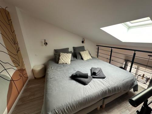 une chambre avec un grand lit avec une lucarne dans l'établissement Le nid Montois, 50m de la plage de la baigneuse, à Saint-Jean-de-Monts