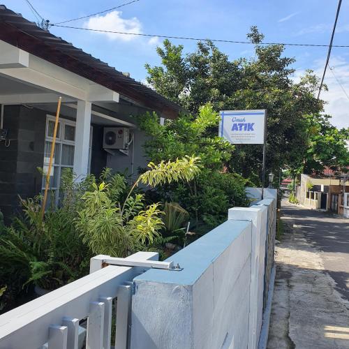 a sign in front of a house with a gate atitz at Omah Atik in Yogyakarta