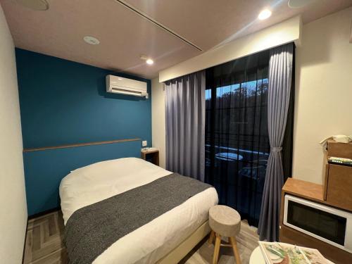 a bedroom with a bed and a window with a balcony at Hotel 螢月ｰhozukiｰ Adult Only in Sendai