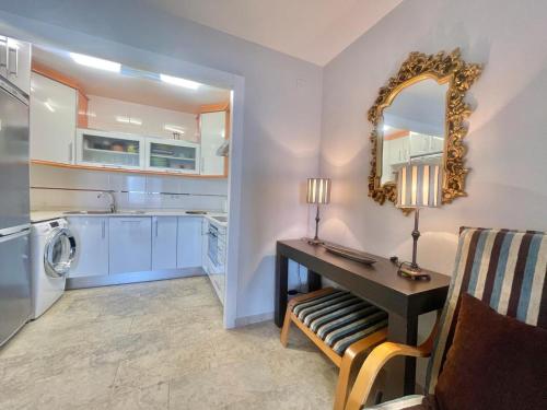 eine Küche mit einem Schreibtisch mit einem Spiegel und einer Waschmaschine in der Unterkunft Coblanca Dream Poniente in Benidorm