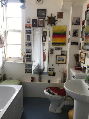 a bathroom with a tub and a toilet and a sink at Guinness Court Shared Apartment in London