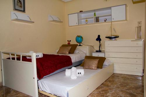 ein Schlafzimmer mit einem weißen Bett und einer weißen Kommode in der Unterkunft Homely Apartments Centro II in Torrevieja