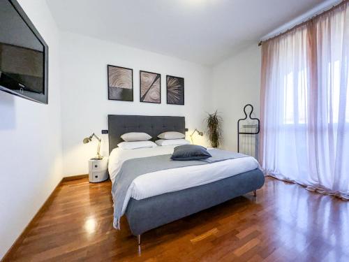 a bedroom with a large bed and a large window at Luxury White Apartment BGY - Orio al Serio Airport in Zanica