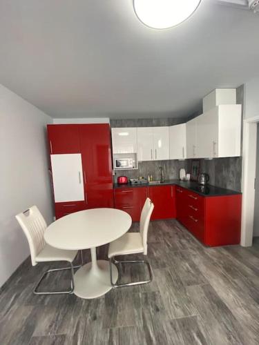 a kitchen with a table and chairs and red cabinets at Apartment Střížkov in Prague