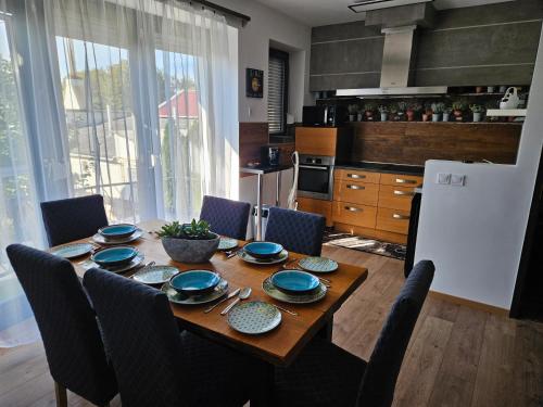 una cocina con una mesa de madera con platos azules. en Tölgyes Apartmanház, en Szeged