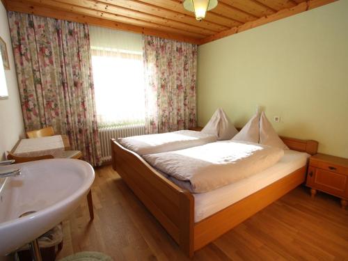 ein Schlafzimmer mit einem Bett, einem Waschbecken und einem Fenster in der Unterkunft Beautiful Holiday Home in Filzmoos with Sauna in Filzmoos