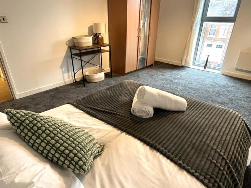 a bedroom with a bed with a towel on it at Central Darlington 2 Bed Flat #8 in Darlington