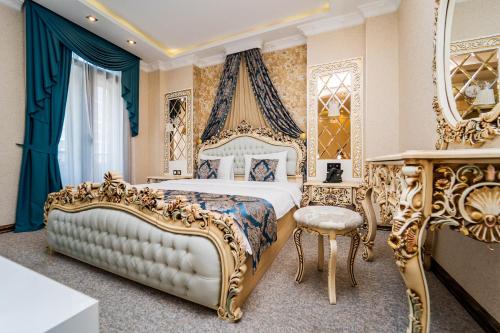 a bedroom with a king sized bed with blue and gold furniture at Hotel Aqua Liberty in Tbilisi City