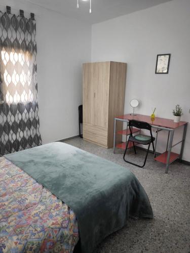 Schlafzimmer mit einem Bett, einem Schreibtisch und einem Tisch in der Unterkunft Casa María in Santa Cruz de Tenerife