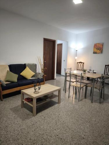 ein Wohnzimmer mit einem Sofa, einem Tisch und Stühlen in der Unterkunft Casa María in Santa Cruz de Tenerife