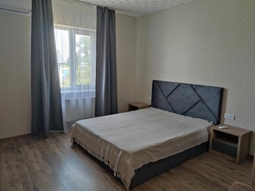 sypialnia z łóżkiem i dużym oknem w obiekcie Будинок де є басейн та дві бесідки w Kijowie