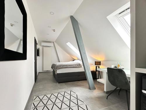 a attic bedroom with a bed and a desk at Si-View Doppelzimmer Siegen Zimmer 15 - Hotel in Siegen