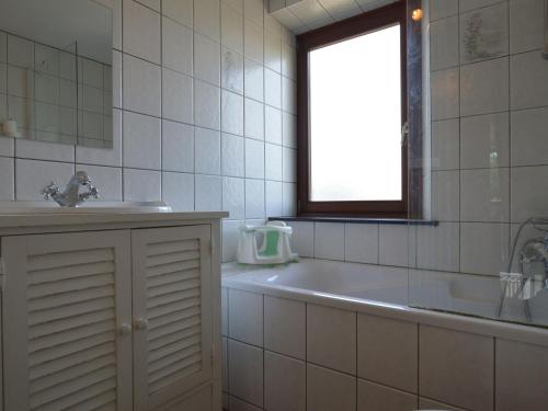 ein Bad mit einer Badewanne, einem Waschbecken und einem Fenster in der Unterkunft Nice holiday home with sauna near Malmedy in Malmedy