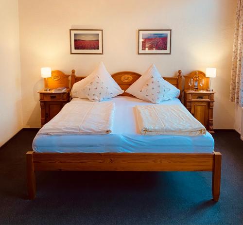 コッヘムにあるホテル ヒーロニミのベッドルーム1室(木製ベッド1台、ナイトスタンド2台付)